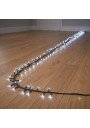 Išvyniota 500 LED šaltai baltos šviesos girlianda ant medinių grindų